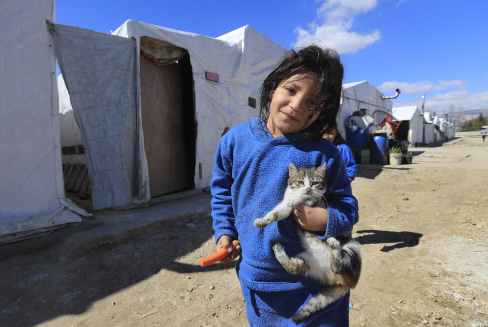 A displaced Syrian girl holds her cat, as she walks on an unpaved street at a refugee camp in Bar Elias, Bekaa Valley, Lebanon, Friday, March 5, 2021. UNICEF said Wednesday, March 10, 2021 that Syria’s 10-year-long civil war has killed or wounded about 12,000 children and left millions out of school in what could have repercussions for years to come in the country. The country's bitter conflict has killed nearly half a million people, wounded more than a million and displaced half the country’s population, including more than 5 million as refugees. (AP Photo/Hussein Malla)