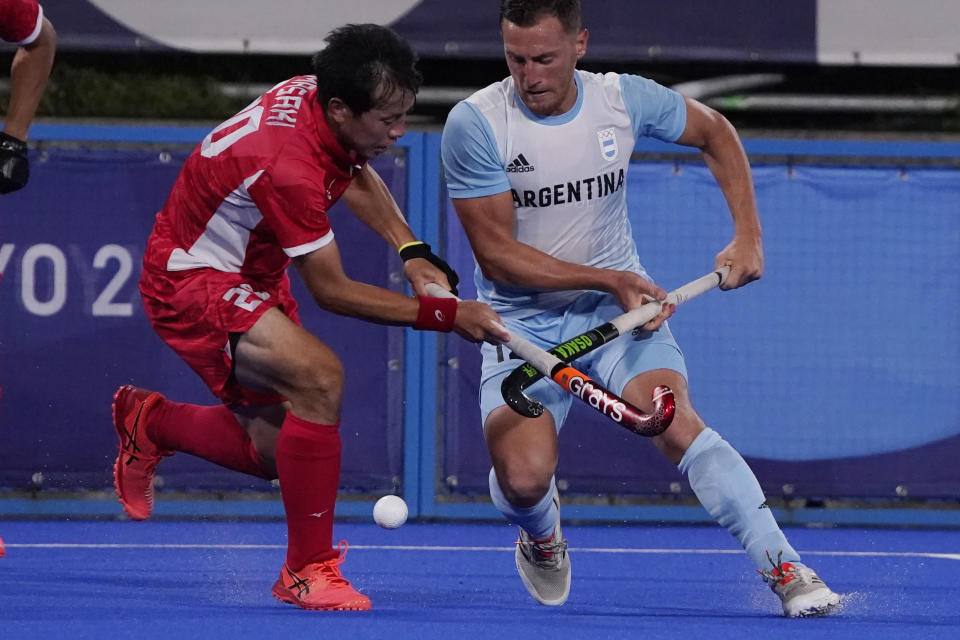 <p>Japan defender Masaki Ohashi (20) and Argentina forward Lucas Martin Vila (12) battle for the ball during a men's field hockey match at the 2020 Summer Olympics, Sunday, July 25, 2021, in Tokyo, Japan. (AP Photo/John Locher)</p> 