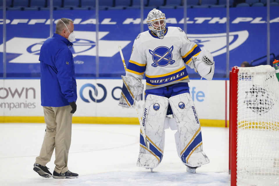 Buffalo Sabres goalie Linus Ullmark (35) is looked at by a Sabres trainer during the first period of an NHL hockey game against the New Jersey Devils, Thursday, Feb. 25, 2021, in Buffalo, N.Y. (AP Photo/Jeffrey T. Barnes)