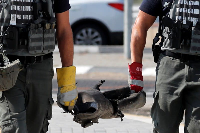 Israeli sappers carry the remains of a rocket in Kiryat Gat, southern Israel