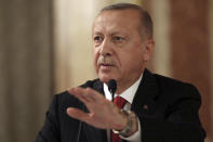 Turkey's President Recep Tayyip Erdogan addresses a conference of parliament speakers in Istanbul, Friday, Oct. 11, 2019. Erdogan says his county "will not take a step back" from its offensive against Syrian Kurdish militants it sees as a national security threat, defying serious warnings from the United States and other Western nations. (Presidential Press Service via AP, Pool)