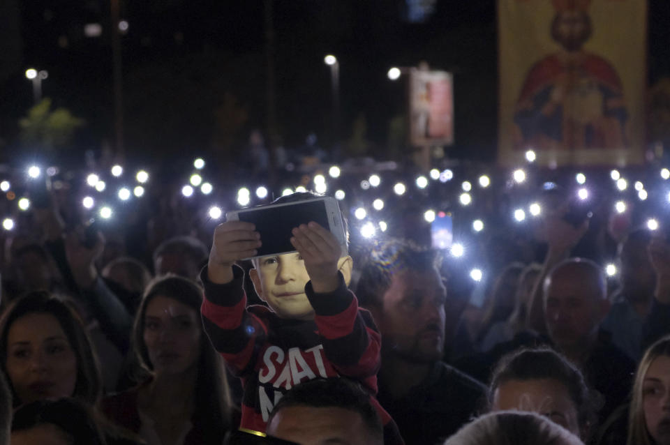 People gather for a protest prayer led by the Serbian Orthodox Church against the holding of an LGBTQ pride march this weekend in Podgorica, Montenegro, Friday, Oct. 7, 2022. The influential church has called its followers in Montenegro to join the prayer for "the sanctity of marriage and preservation of family" after organizing a similar gathering in neighboring Serbia ahead of a pan-European pride event there last month. (AP Photo/Risto Bozovic)