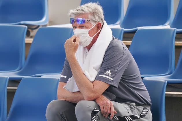 A spectator wears a mask as smoke haze shrouds Melbourne during an Australian Open practice session at Melbourne Park in Australia, Tuesday, Jan. 14, 2020. Smoke haze and poor air quality caused by wildfires temporarily suspended practice sessions for the Australian Open at Melbourne Park on Tuesday, but qualifying began later in the morning in