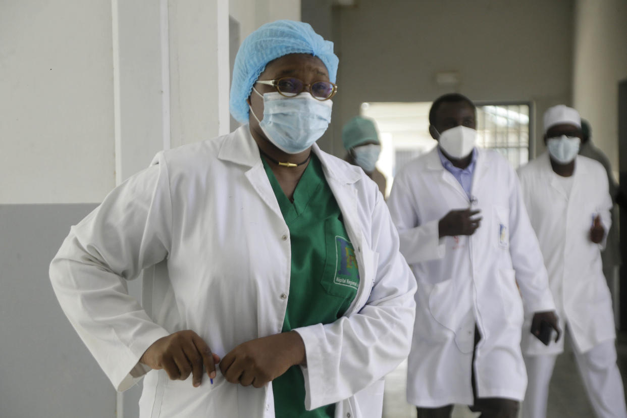 Dr. Oumaima Djarma, left, walks with other doctors dealing with COVID-19 patients, inside the Farcha provincial hospital in N'Djamena, Chad, Friday April 30, 2021.  While the world's wealthier nations have stockpiled coronavirus vaccines for their citizens, many poorer countries are scrambling to secure enough doses, and some, like Chad, have yet to receive any. (AP Photo/Sunday Alamba)