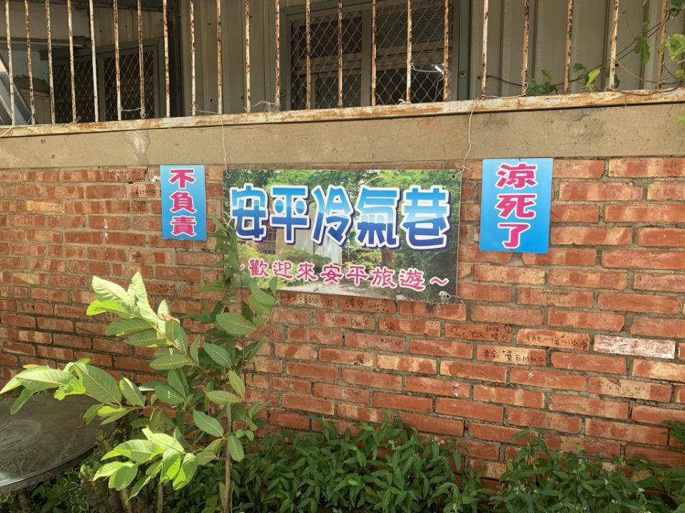 張姓屋主在安平區運河路巷內圍牆，掛起「安平冷氣巷」等看板，讓人好奇。 （記者陳銀全攝）