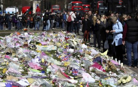 Onlookers view floral tributes laid in Parliament Square following the attack in Westminster earlier in the week, in central London, Britain March 26, 2017. REUTERS/Neil Hall