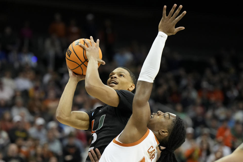 Miami guard Isaiah Wong shoots over Texas guard Marcus Carr in the first half of an Elite 8 college basketball game in the Midwest Regional of the NCAA Tournament Sunday, March 26, 2023, in Kansas City, Mo. (AP Photo/Jeff Roberson)