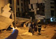 <p>Two guests are escorted by rescue workers from the damaged Marshal Hotel in Hualien, eastern Taiwan early February 7, 2018, after a strong earthquake struck the island. (Photo: Yang Jen-Fu/AFP/Getty Images) </p>