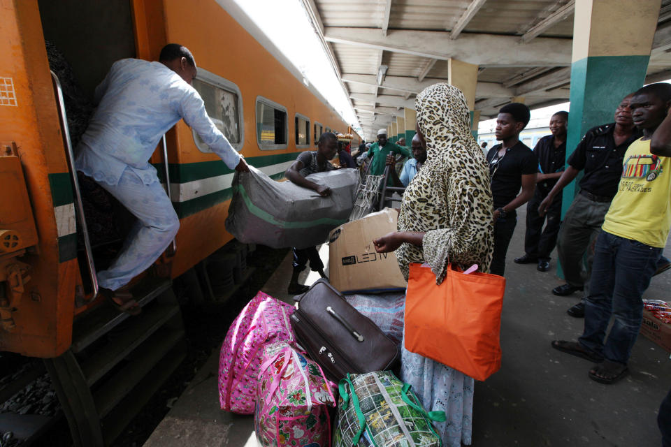 In this Photo taken, Friday, March . 8, 2013, passengers board an Ooni of Ife train to Kano, in Lagos, Nigeria. Nigeria reopened its train line to the north Dec. 21, marking the end of a $166 million project to rebuild portions of the abandoned line washed out years earlier. The state-owned China Civil Engineering Construction Corp. rebuilt the southern portion of the line, while a Nigerian company handled the rest.( AP Photo/Sunday Alamba)