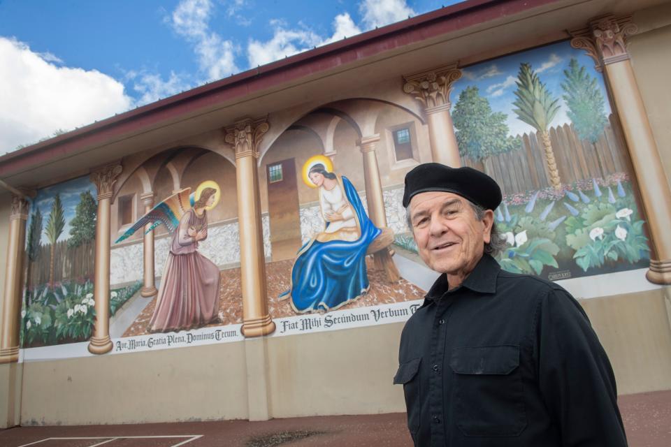 Muralist Carlos Lopez stands next to one of his favorite murals, a scene of St. John the Baptist and the Virgin Mary that he painted in 2002 at Annunication School in Stockton. 