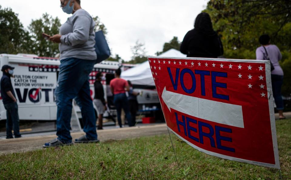 Voters line up for early voting at a Fulton County mobile voting station Monday morning, Oct. 12, 2020 at St. Paul's Episcopal Church in Southwest Atlanta. Monday was the first day of early voting, and the first time the county's new mobile voting stations were used.