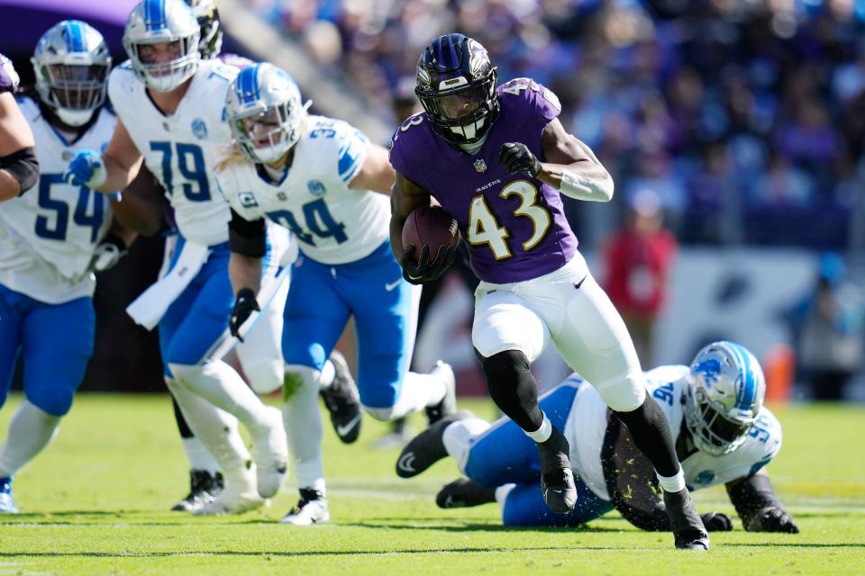 Ravens running back Justice Hill rushes during the first half on Sunday, Oct. 22, 2023, in Baltimore.