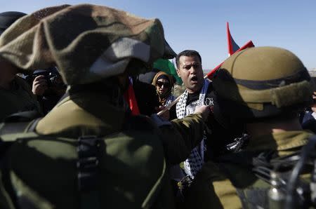 A Palestinian protester argues with Israeli soldiers during a protest against Jewish settlements near the West Bank city of Ramallah December 10, 2014. REUTERS/Mohamad Torokman