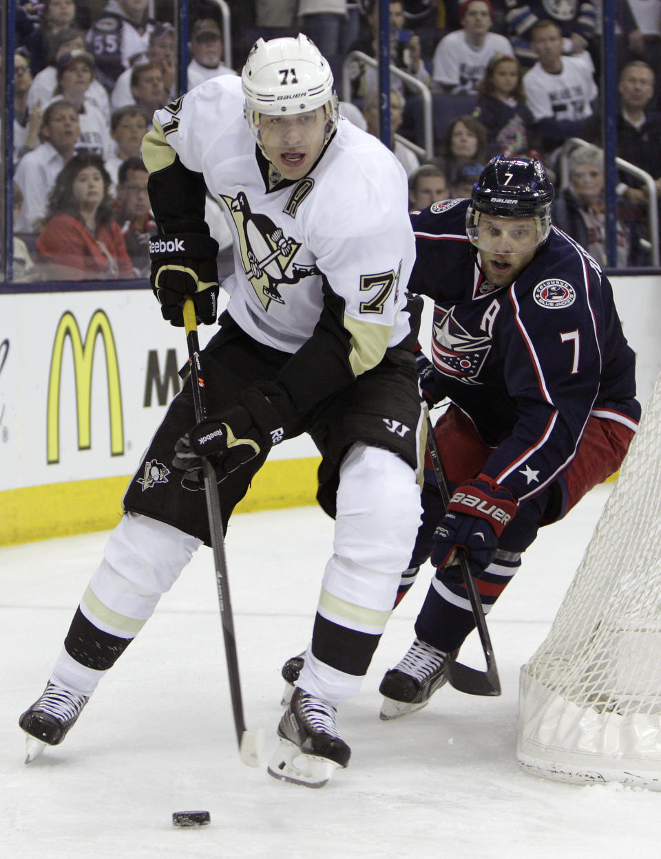 Pittsburgh Penguins' Evgeni Malkin, left, of Russia, carries the puck around the net as Columbus Blue Jackets' Jack Johnson defends during the first period of Game 6 of a first-round NHL playoff hockey series Monday, April 28, 2014, in Columbus, Ohio. (AP Photo/Jay LaPrete)