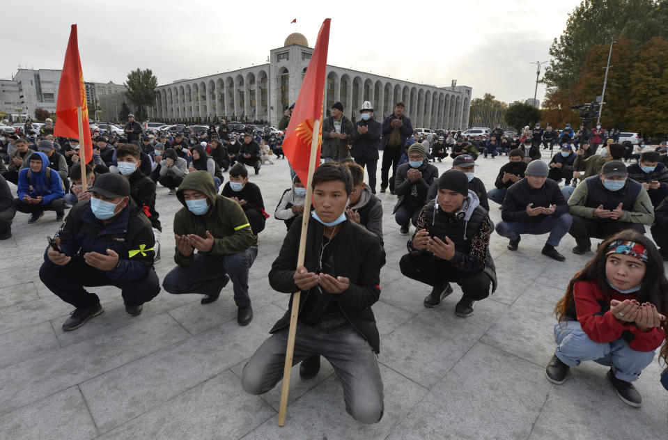 People pray during a rally on the central square in Bishkek, Kyrgyzstan, Friday, Oct. 9, 2020 Sooronbai Jeenbekov, the embattled president of Kyrgyzstan, has moved to end the political turmoil that followed a disputed parliamentary election, ordering a state of emergency in the capital. Jeenbekov has faced calls to resign by protesters who stormed government buildings after Sunday’s parliamentary vote was reportedly swept by pro-government parties. Protesters freed former President Almazbek Atambayev, who was jailed on charges seen by his supporters as a political vendetta. (AP Photo/Vladimir Voronin)