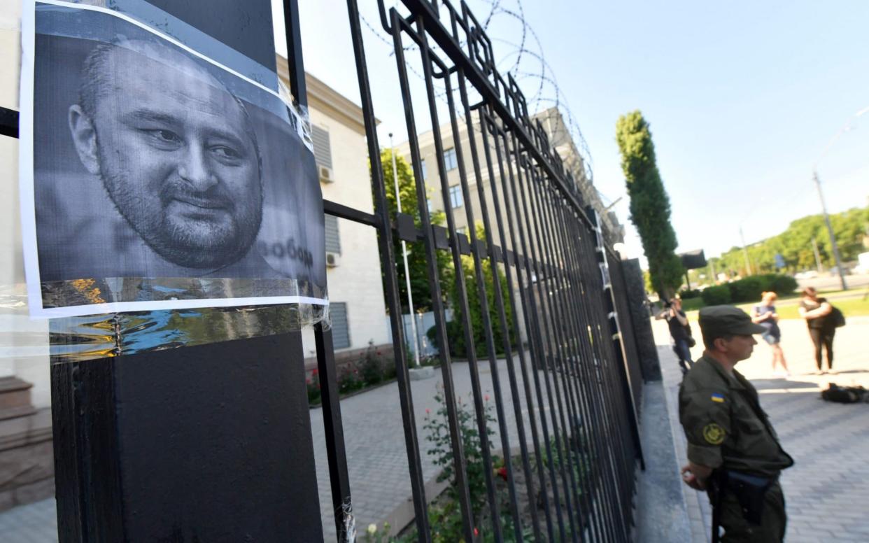 Activists have posted portraits of Arkady Babchenko posted on the gates of the Russian embassy in Kiev - AFP