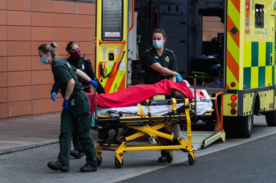 <p>Paramedics transport a patient from the ambulance to the emergency department at the the Royal London Hospital</p> (Getty)