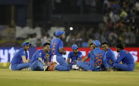 India players sit on the field after the match was disrupted due to water bottles thrown by spectators during the second Twenty20 cricket match against South Africa in Cuttack, India, October 5, 2015. REUTERS/Danish Siddiqui