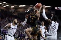 Wichita State guard Xavier Bell (1) shoots between Kansas State guards Desi Sills (13) and Cam Carter (5) during the first half of an NCAA college basketball game Saturday, Dec. 3, 2022, in Manhattan, Kan. (AP Photo/Charlie Riedel)