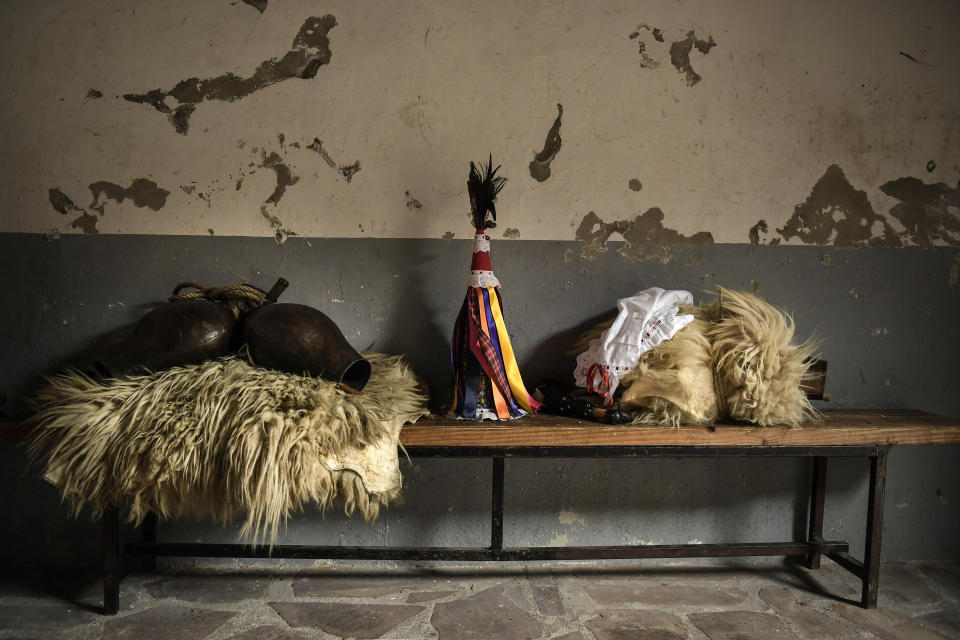 In this Monday, Jan. 27, 2020 photo, sheepskins, a conical caps with ribbons and cowbells, elements used by "Joaldunak", are seen on a bench ahead of a Carnival in the small Pyrenees village of Zubieta, northern Spain. In one of the most ancient carnival celebrations in Europe, dozens of people don sheepskins, lace petticoats and conical caps and sling cowbells across their lower backs as they parade to herald the advent of spring. (AP Photo/Alvaro Barrientos)