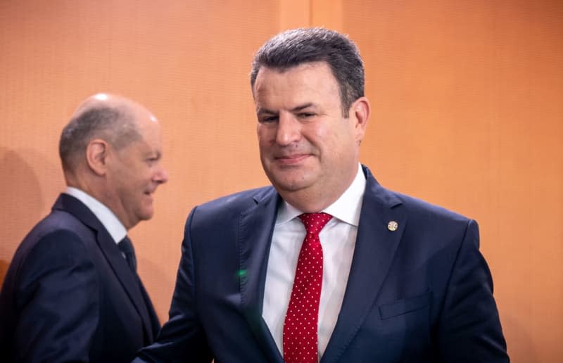 German Chancellor Olaf Scholz (L) arrives behind Hubertus Heil (R), the German Minister of Labor and Social Affairs, at the meeting of the German cabinet in the Chancellery.  Michael Kappeler/dpa