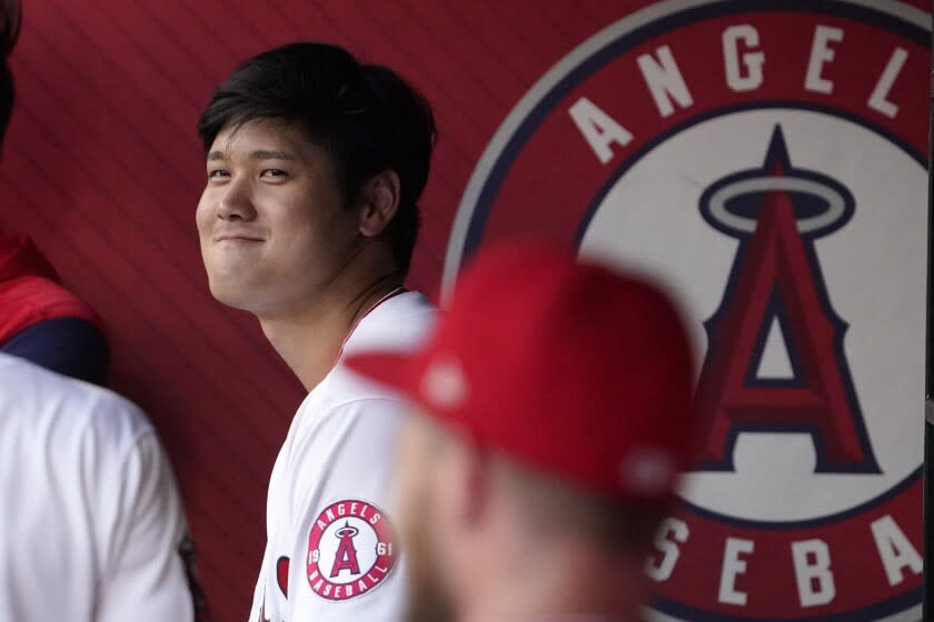 Los Angeles Angels' Shohei Ohtani stands in the dugout as he waits to hit during the first inning of a baseball game against the Miami Marlins Monday, April 11, 2022, in Anaheim, Calif. (AP Photo/Mark J. Terrill)