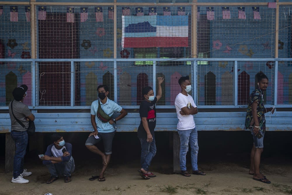 Voters wearing protective masks queue up to cast their votes during the Sabah state election in SK Pulau Gaya September 26, 2020. — Picture by Firdaus Latif