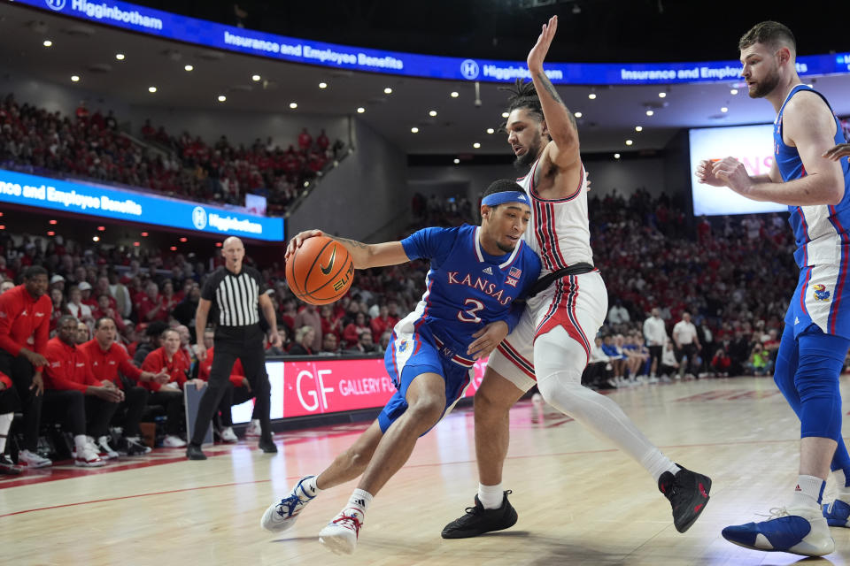 Kansas' Dajuan Harris Jr. (3) drives toward the basket as Houston's Emanuel Sharp defends during the first half of an NCAA college basketball game Saturday, March 9, 2024, in Houston. (AP Photo/David J. Phillip)