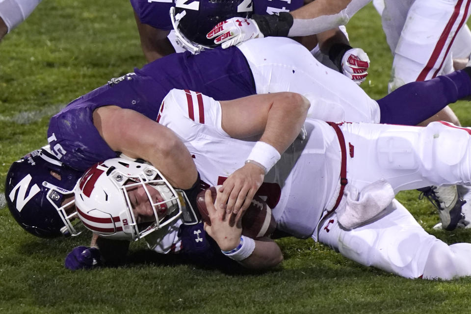 Northwestern linebacker Blake Gallagher, top, sacks Wisconsin quarterback Graham Mertz during the second half of an NCAA college football game in Evanston, Ill., Saturday, Nov. 21, 2020. Northwestern won 17-7. (AP Photo/Nam Y. Huh)