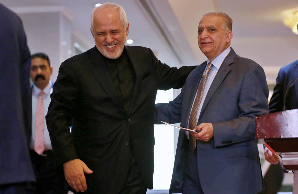 Iraqi Foreign Minister Mohamed Alhahkim, right, talks with his Iranian counterpart Mohammad Javad Zarif, after their press conference at the Ministry of Foreign Affairs in Baghdad, Iraq, Sunday, May 26, 2019. (AP Photo/Khalid Mohammed)