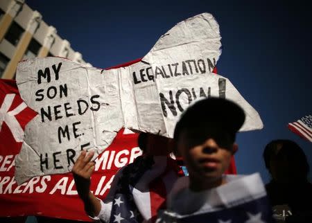 An undocumented immigrant who said she has lived in the U.S. for 26 years, holds a sign as she marches with her son to demand immigration reform in Hollywood, Los Angeles, California, October 5, 2013. REUTERS/Lucy Nicholson