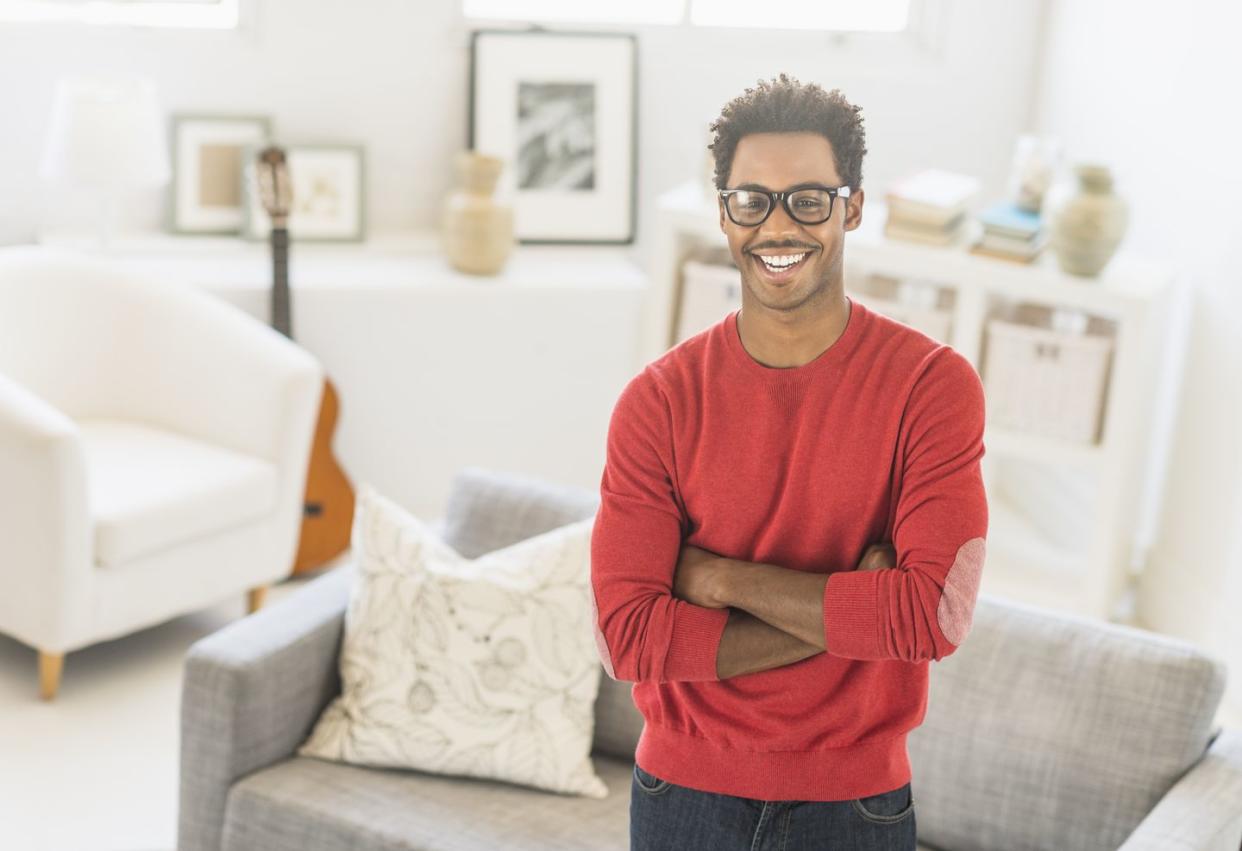 man wearing spectacles standing in living room
