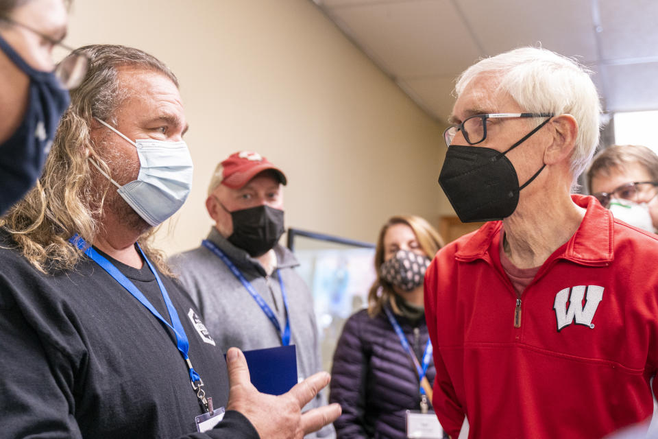 Wisconsin Gov. Tony Evers, right, talks with International Brotherhood of Electrical Workers union member Dan Diece Saturday, Jan. 8, 2022, in Janesville, Wis. The 70-year-old grandfather and former teacher is trying to convince voters that he's also a valiant defender of democracy and the lone figure ensuring their votes will still matter in 2024 and beyond. (AP Photo/Andy Manis)