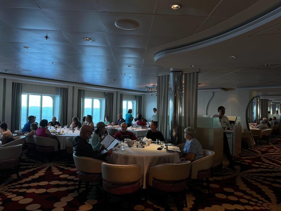 dim dining room on a cruise ship filled with people eating during the day