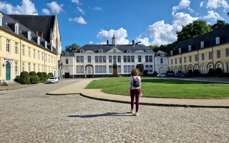 A young woman walking towards the abbey of La Cambre / Abbey ter Kameren in Brussels, Belgium