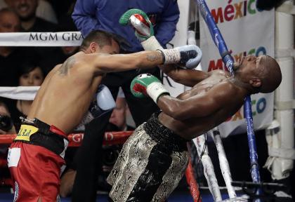 Marcos Maidana (L) works against Floyd Mayweather during their second bout. (AP)