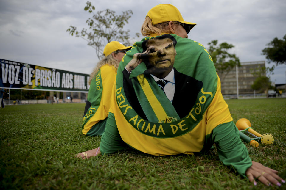 Women supporters of Brazilian incumbent President Jair Bolsonaro, wearing shirts with the president´s likeness, wait for results after general election polls closed in Brasilia, Brazil, Sunday, Oct. 2, 2022. (AP Photo/Ton Molina)