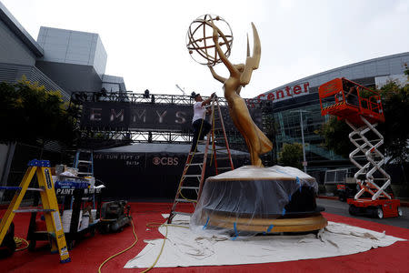 A worker touches up an Emmy statue during preparations for the 69th Emmy Awards at Microsoft Theater in Los Angeles, California, U.S., September 12, 2017. REUTERS/Mario Anzuoni