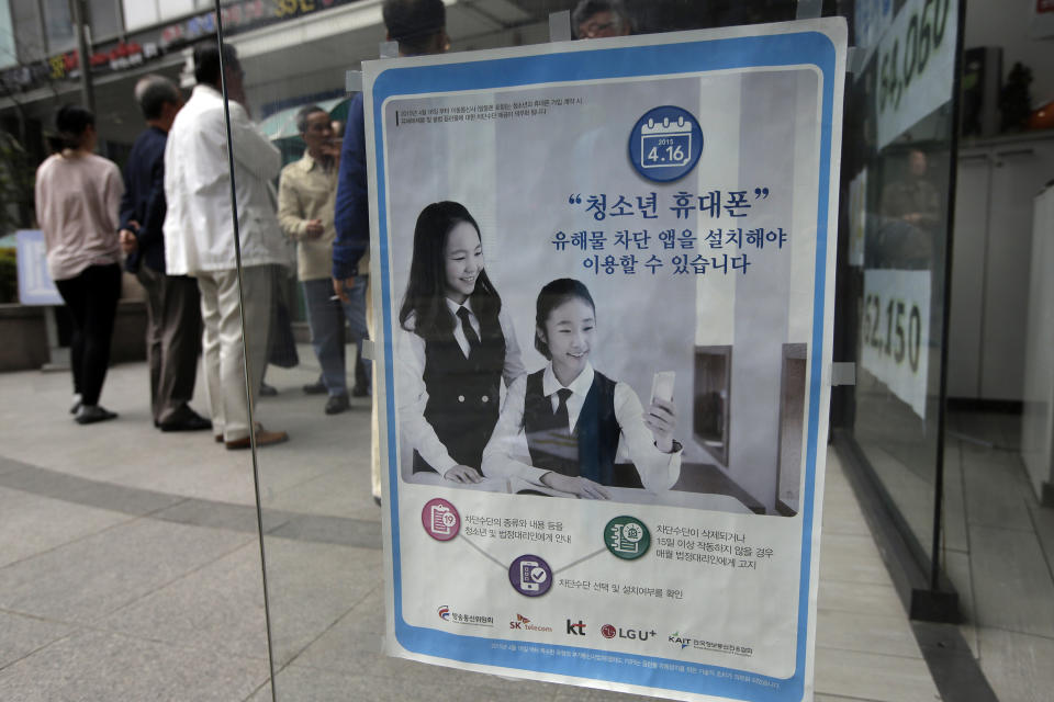 Image: A promotional banner of mobile apps that block harmful content, is posted on the door at a mobile store in Seoul, South Korea. (Lee Jin-man / AP file)