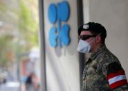 An Austrian army member stands next to the OPEC logo in front of their headquarters in Vienna