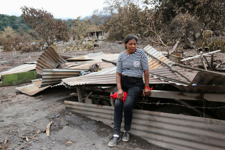 A woman takes a break in an affected area after the eruption of the Fuego volcano in San Miguel, Escuintla, Guatemala, June 8, 2018. REUTERS/Luis Echeverria