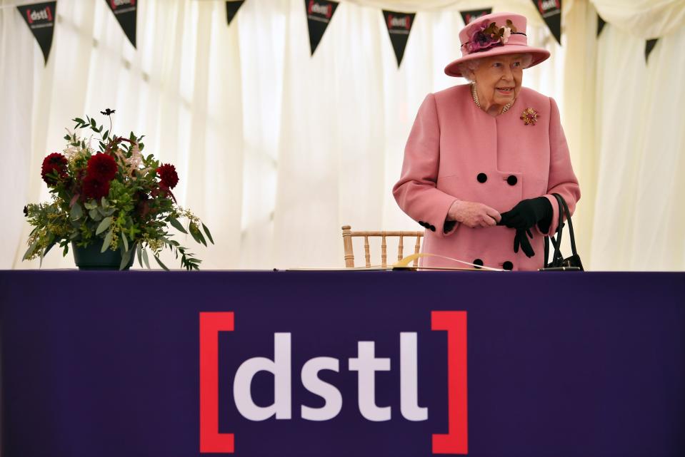 Britain's Queen Elizabeth II stands after signing a visitor's book during her visit to the Defence Science and Technology Laboratory (Dstl) at Porton Down science park near Salisbury, southern England, on October 15, 2020. - The Queen and the Duke of Cambridge visited the Defence Science and Technology Laboratory (Dstl) where they were to view displays of weaponry and tactics used in counter intelligence, a demonstration of a Forensic Explosives Investigation and meet staff who were involved in the Salisbury Novichok incident. Her Majesty and His Royal Highness also formally opened the new Energetics Analysis Centre. (Photo by Ben STANSALL / POOL / AFP) (Photo by BEN STANSALL/POOL/AFP via Getty Images)