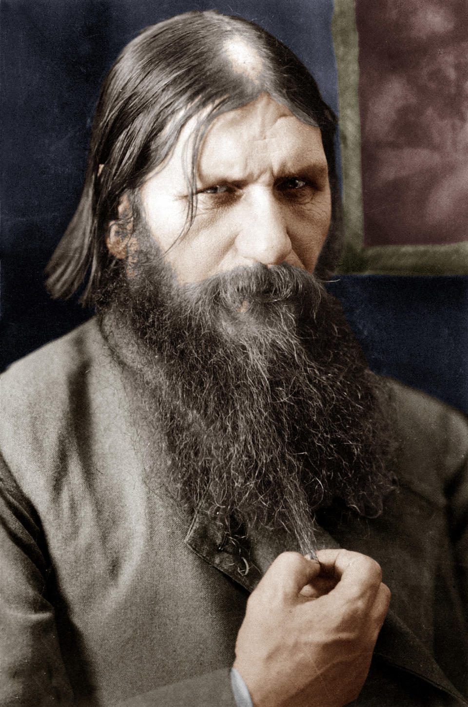 A man with a long beard and intense expression, wearing a suit, with vintage style photography