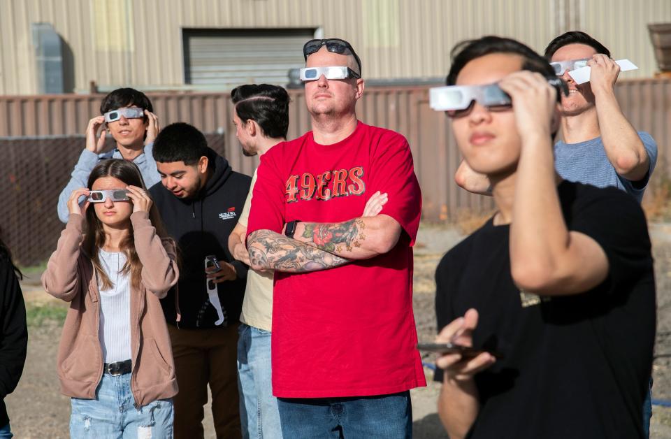 Eclipse watchers look at the sun through special protective glasses during a watch party held by the Delta College Physics-Math-Computer Sciences Club and the the Stockton Astronomical Society on the campus of San Joaquin Delta College in Stockton on Oct. 14, 2023. About 50 people attended the event. A solar eclipse is when the moon comes between the Earth and Sun. Stockton was joust outside of the eclipse's path and experiences only a partial eclipse covering most but all of the Sun. The Oct. 14 eclipse was an annular eclipse. That's when the moon is at its farthest from the Earth and it doesn't entirely block out the Sun but leaves a ring often called the "ring of fire." A total eclipse will occur on April, 8 2024.