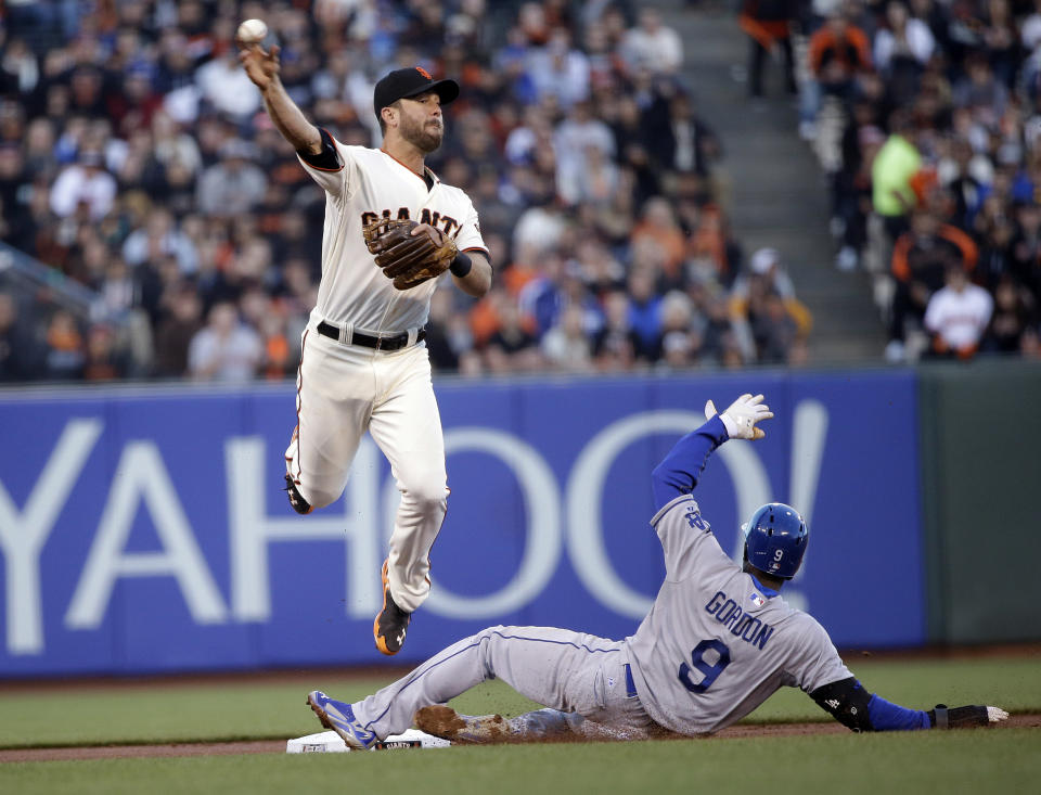 San Francisco Giants second baseman Brandon Hicks, top, turns a double play over Los Angeles Dodgers' Dee Gordon (9) on a ground ball by Hanley Ramirez during the first inning of a baseball game on Wednesday, April 16, 2014, in San Francisco. (AP Photo/Marcio Jose Sanchez)