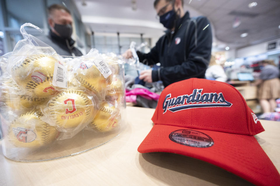 Ben Traska, right, helps customer John Marquart at the opening of the Cleveland Guardians team store in Cleveland, Friday, Nov. 19, 2021. It's Day One for the Guardians, who put caps, jerseys and other merchandise on sale to the public for the first time since dropping the name Indians, the franchise's identity since 1915. (AP Photo/Ken Blaze)