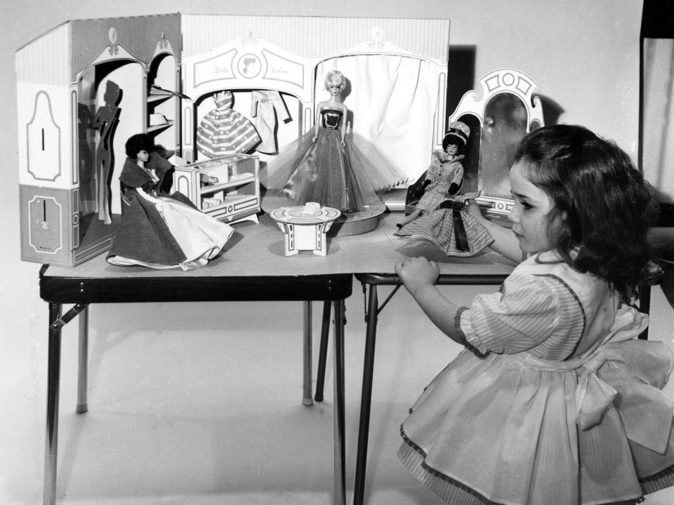 A young girl plays with Barbie dolls in 1963.