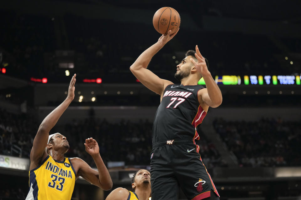 Miami Heat center Omer Yurtseven (77) shoots over Indiana Pacers center Myles Turner during the first half of an NBA basketball game in Indianapolis, Friday, Dec. 3, 2021. (AP Photo/AJ Mast)