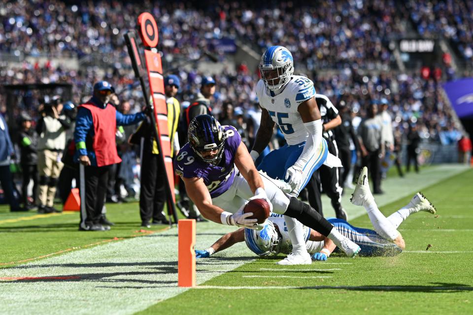 Baltimore Ravens tight end Mark Andrews dives past Detroit Lions linebackers Jack Campbell (46) and Derrick Barnes (55) for a touchdown in the second quarter at M&T Bank Stadium, Oct. 22, 2023.