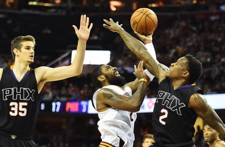 Jan 19, 2017; Cleveland, OH, USA; Cleveland Cavaliers guard Kyrie Irving (2) drives to the basket between Phoenix Suns forward Dragan Bender (35) and guard Eric Bledsoe (2) during the first half at Quicken Loans Arena. Mandatory Credit: Ken Blaze-USA TODAY Sports